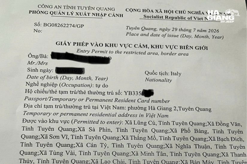 Ha Giang border permit document held over mountain landscape