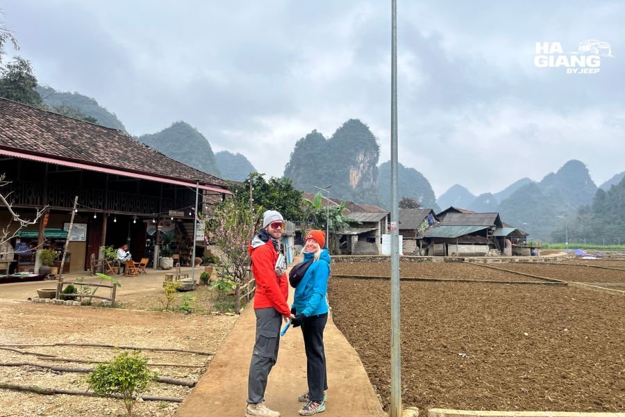 Local family interaction during Ha Giang jeep tour in Cao Bang village demonstrating cultural exchange and authentic travel connection