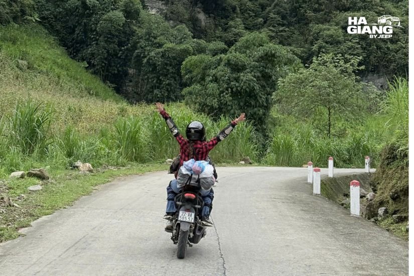 Motorbike riders navigating winding mountain road Ha Giang border region