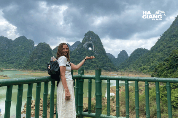 Travellers stopping with a private open-air jeep at a scenic Cao Bang viewpoint overlooking valley formations