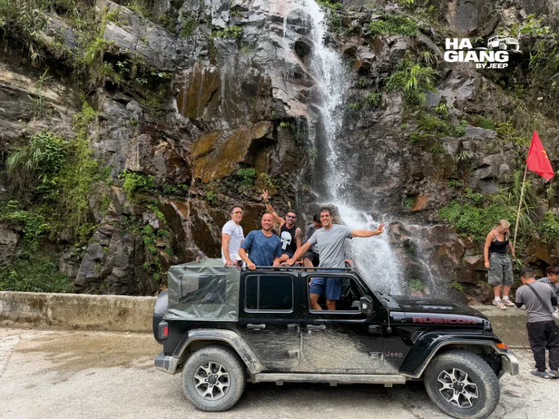 Ha Giang jeep tour stop at a waterfall near Du Gia