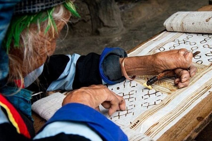 Beeswax batik drawing on hemp cloth at Lung Tam Linen Village