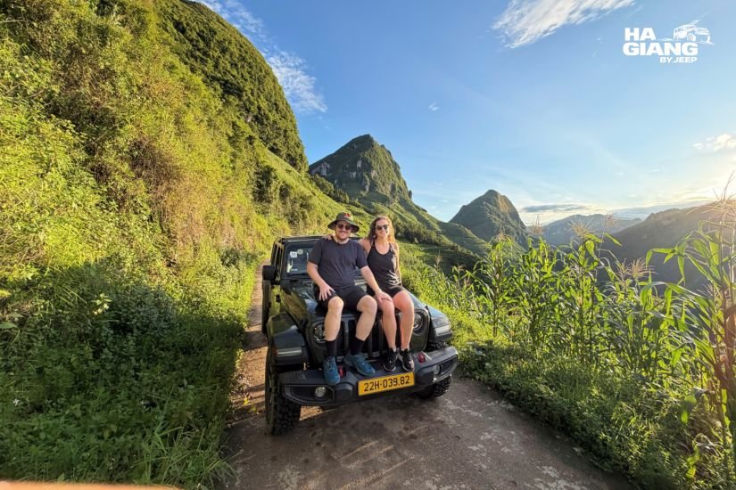 Jeep driving on Ma Pi Leng Pass with dramatic limestone mountains at sunrise, Ha Giang