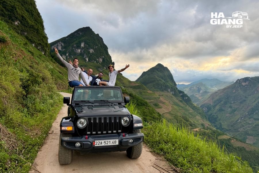 Jeep with soft top up on a wet Ma Pi Leng Pass during the Ha Giang Loop rainy season