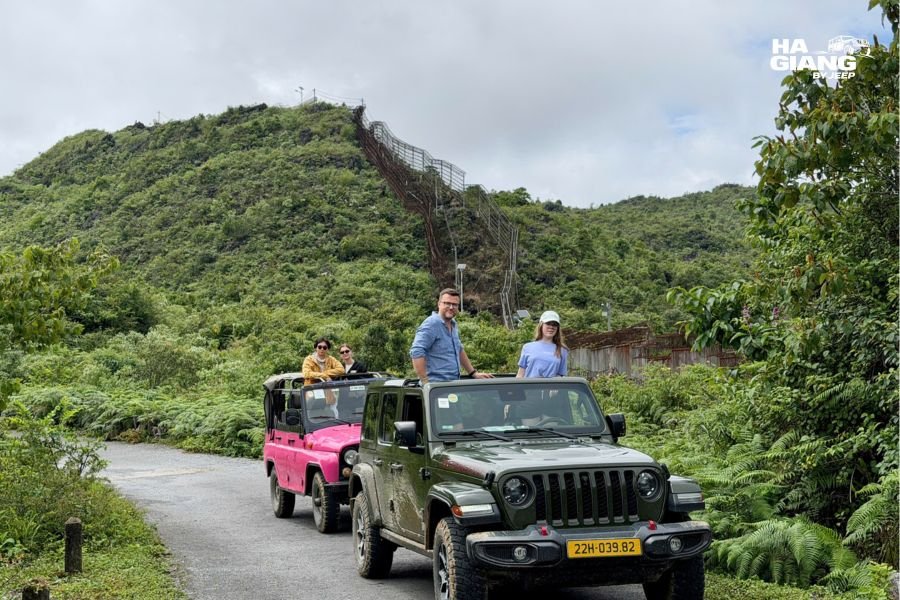 Older travelers stepping out of a private jeep beside a buckwheat field in Ha Giang