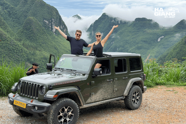Ha Giang jeep tour what to expect: open air jeep parked above Tam Son valley on the drive to Lung Khuy Cave