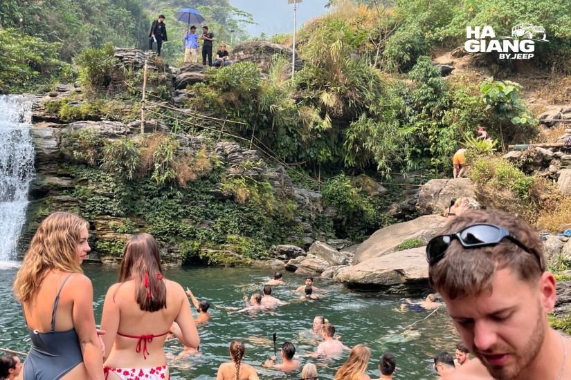 Travelers cooling off at Du Gia waterfall on day 4 of the loop