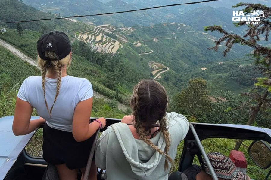 Travelers standing beside an open top jeep above the Hoang Su Phi rice terraces