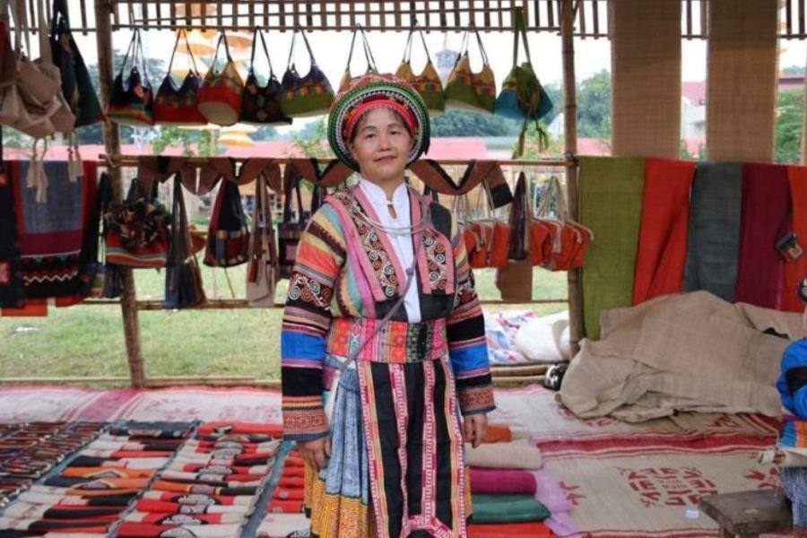 Weaver at a wooden loom inside Lung Tam Linen Village in Ha Giang