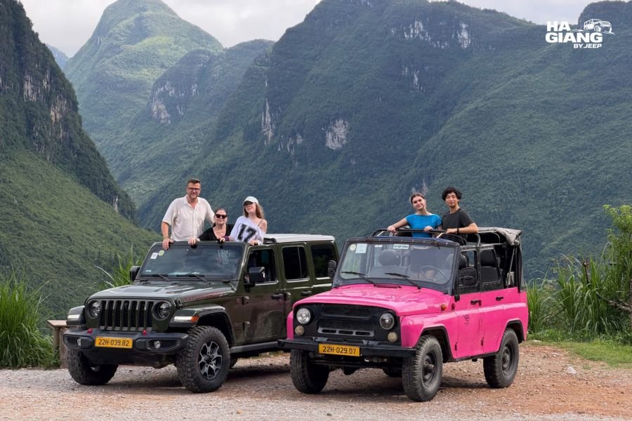 A family at Ma Pi Leng Pass, some at the rail and one seated nearby