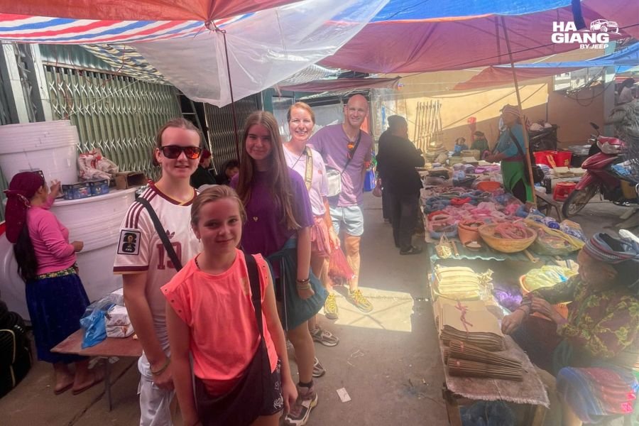 An older traveler looking at textiles with a Hmong vendor at a Ha Giang market