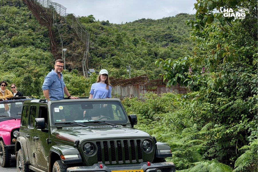 English-speaking local driver preparing private jeep for tour with female traveler