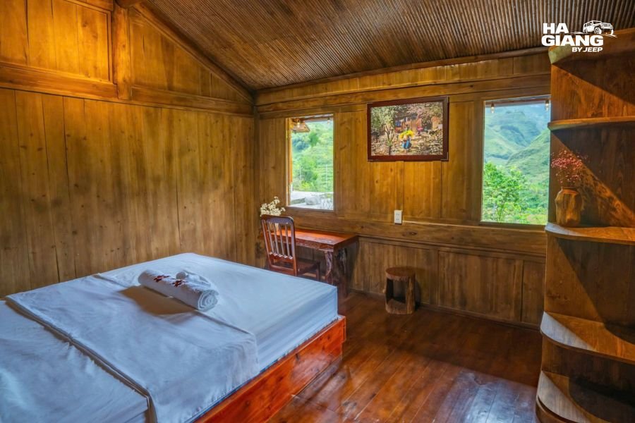 Exterior view of traditional mountain homestay building with terrace and valley landscape