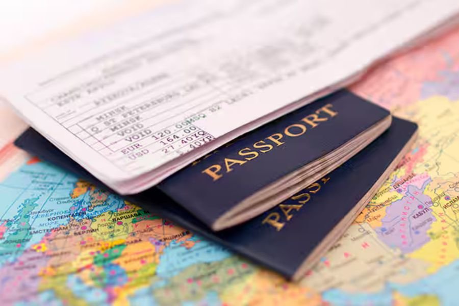 Flat-lay of travel documents: passport, travel insurance card, Vietnamese cash (VND), and credit cards neatly arranged