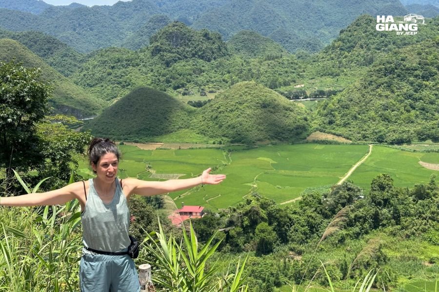 Ha Giang solo travel: a solo traveler beside an open top jeep at a Ma Pi Leng viewpoint