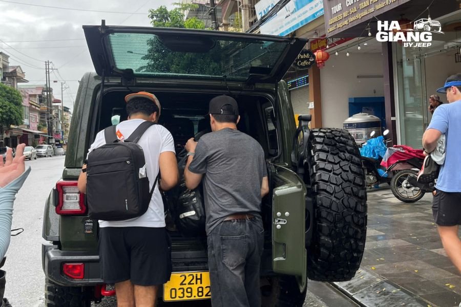 Traveler with packing checklist clipboard next to fully packed Ha Giang jeep, ready-to-depart mood
