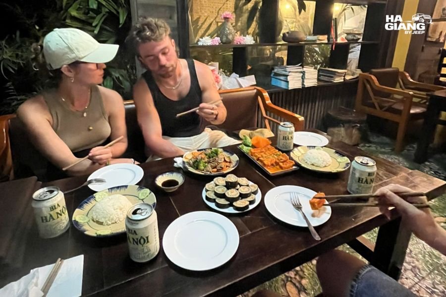 Travelers enjoying street food in comfortable clothing during Ha Giang jeep break