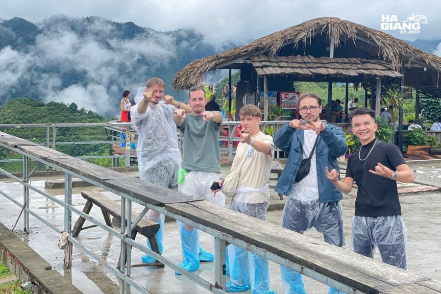 Travelers wearing waterproof jacket during light rain on Ha Giang jeep tour