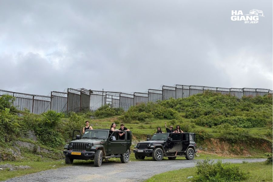 Two jeeps travelling in convoy on a switchback road in Ha Giang
