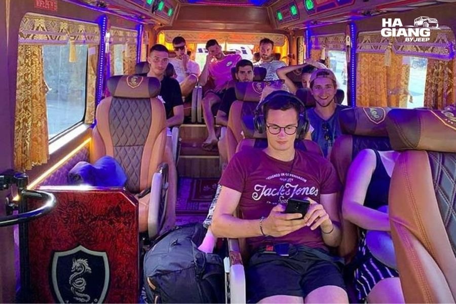 Day bus on Vietnam mountain road with passengers, offering daytime travel option from Hanoi to Ha Giang with better comfort than sleeper buses