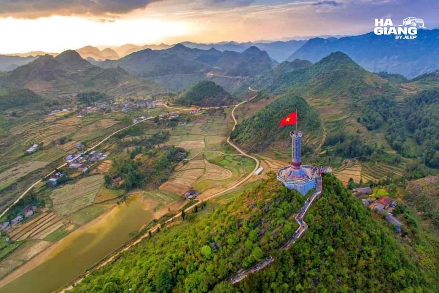 Lung Cu Flag Tower on mountain peak with panoramic views over Ha Giang landscape and nearby Laos, accessible scenic viewpoint