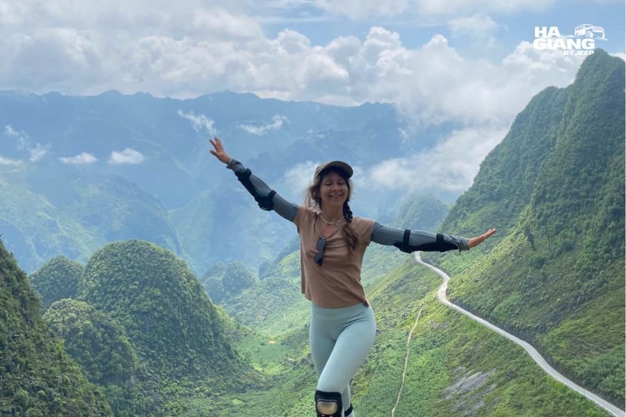 Dramatic Ma Pi Leng Pass with limestone cliffs, winding mountain road, and scenic valley views on Ha Giang Loop jeep tour