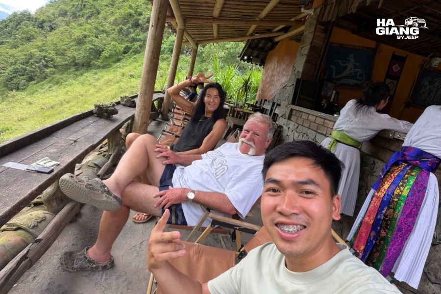 Mature travelers exploring Ha Giang village, interacting with locals, experiencing authentic mountain culture without exhaustion