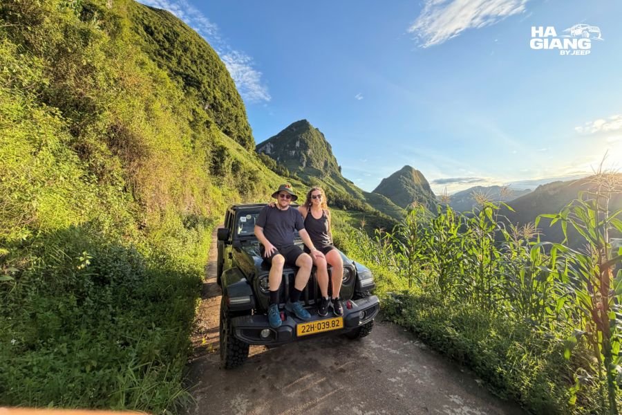 Mature couple enjoying Ha Giang Loop jeep tour with mountain views, smiling in open-air Jeep Wrangler