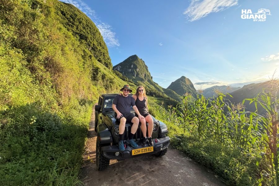 Couple travelling in an open air jeep past terraced fields on the Ha Giang Loop