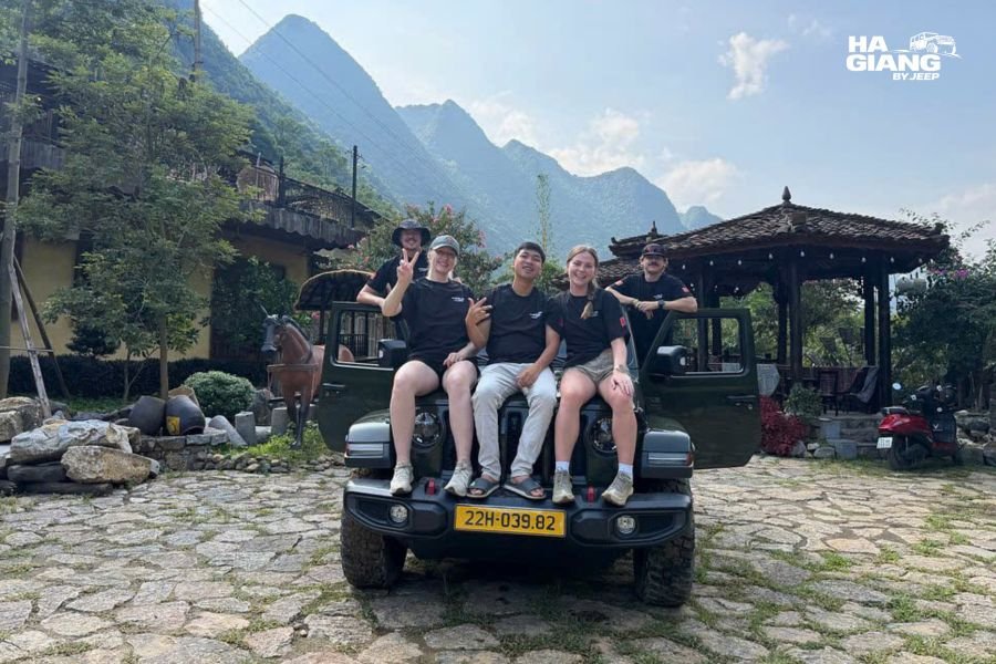Open top jeep parked beside the Quay Son River in Cao Bang with karst peaks behind