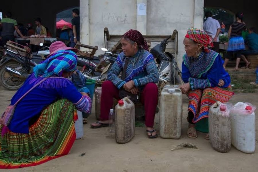 Roadside stall near Ma Pi Leng Pass selling local corn wine in plastic containers