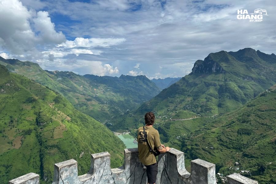 Traveler checking mobile signal for a Ha Giang SIM card at a viewpoint on Ma Pi Leng Pass