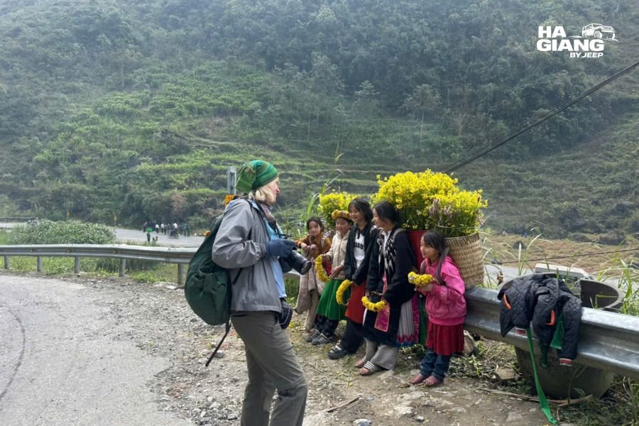 Travelers and local children in a Ha Giang village where several languages are spoken