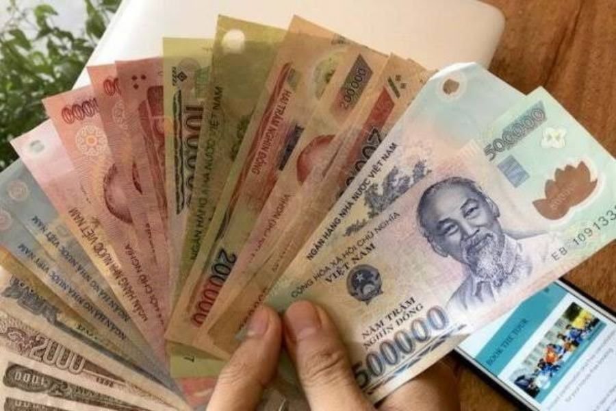 Vietnamese dong banknotes in different denominations sorted on a table before a Ha Giang Loop trip